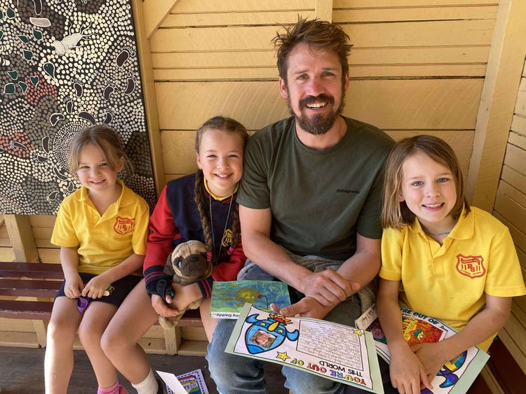 A photo of a father smiling with his children who are enrolled at Hannam Vale Public School.