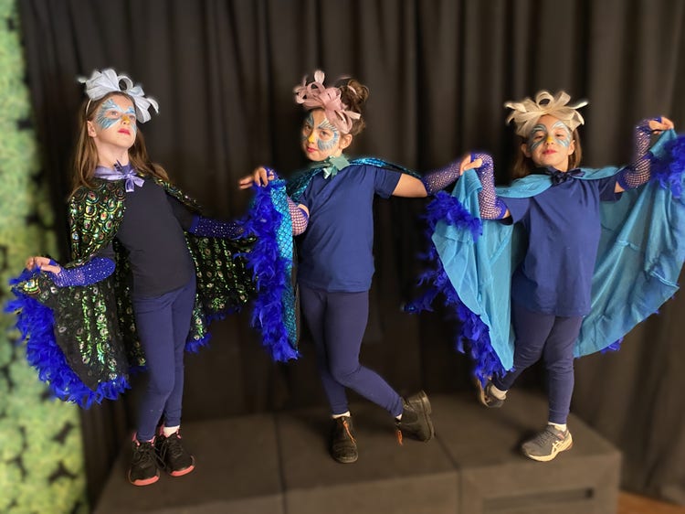 A photo of female students dressed as birds performing in the school musical.