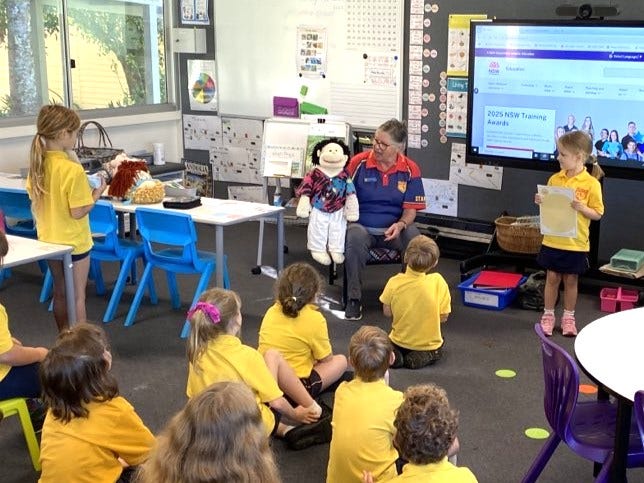 A photo of the classroom teacher delivering a lesson using a puppet to engage students.