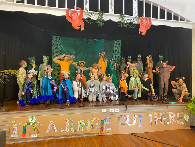 A photo of students on stage performing in the school musical production.